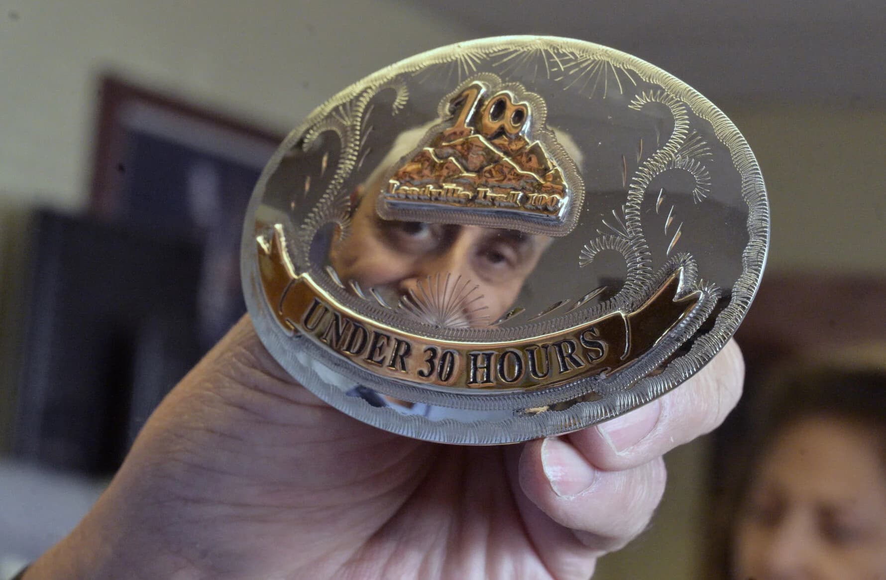 A silver Leadville 100 belt buckle with 'UNDER 30 HOURS' inscription